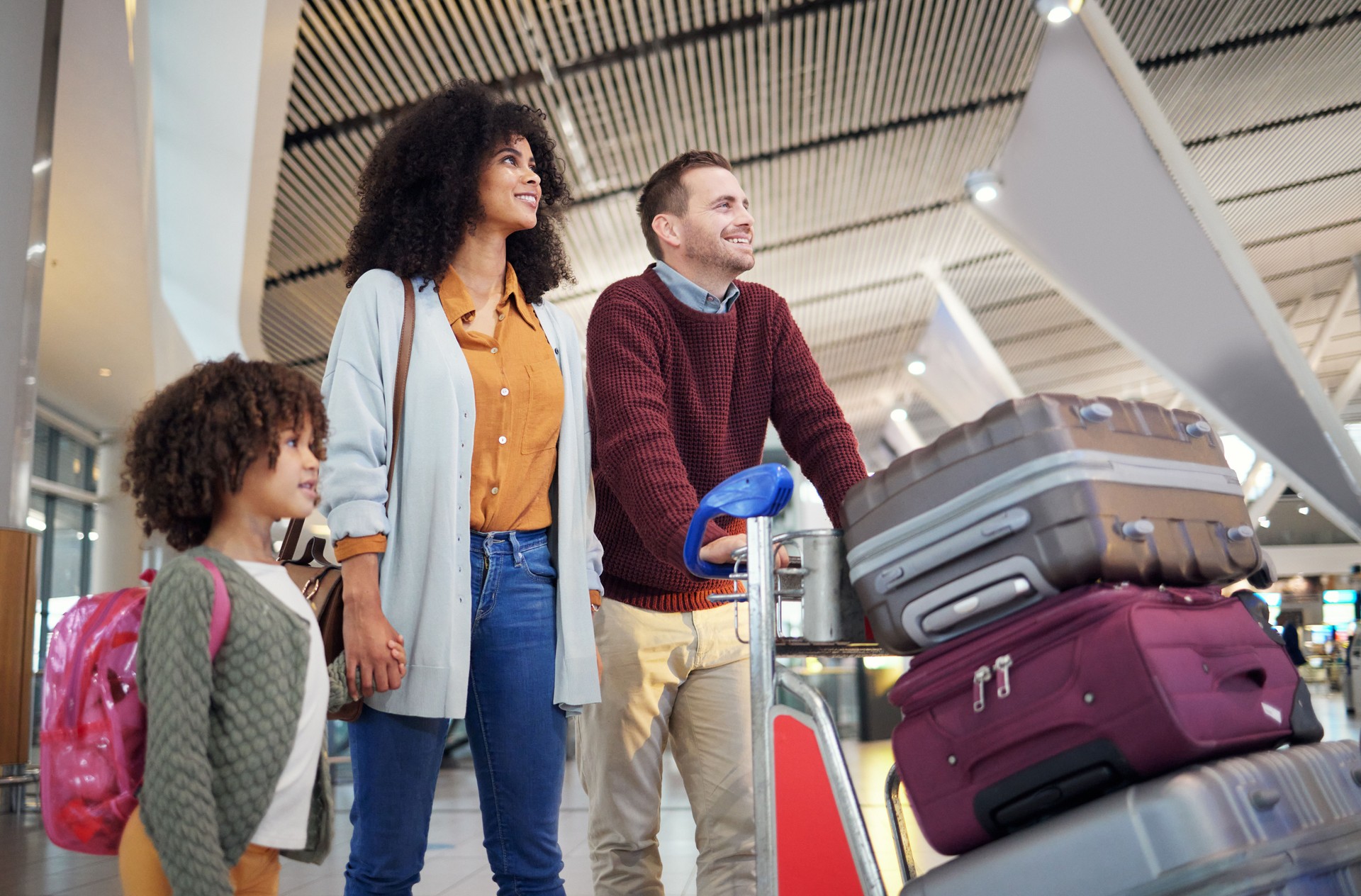 Travel, airport and happy family with luggage for holiday, vacation or immigration for international journey. Suitcase, bag and black woman or diversity parents with child or kid walking together